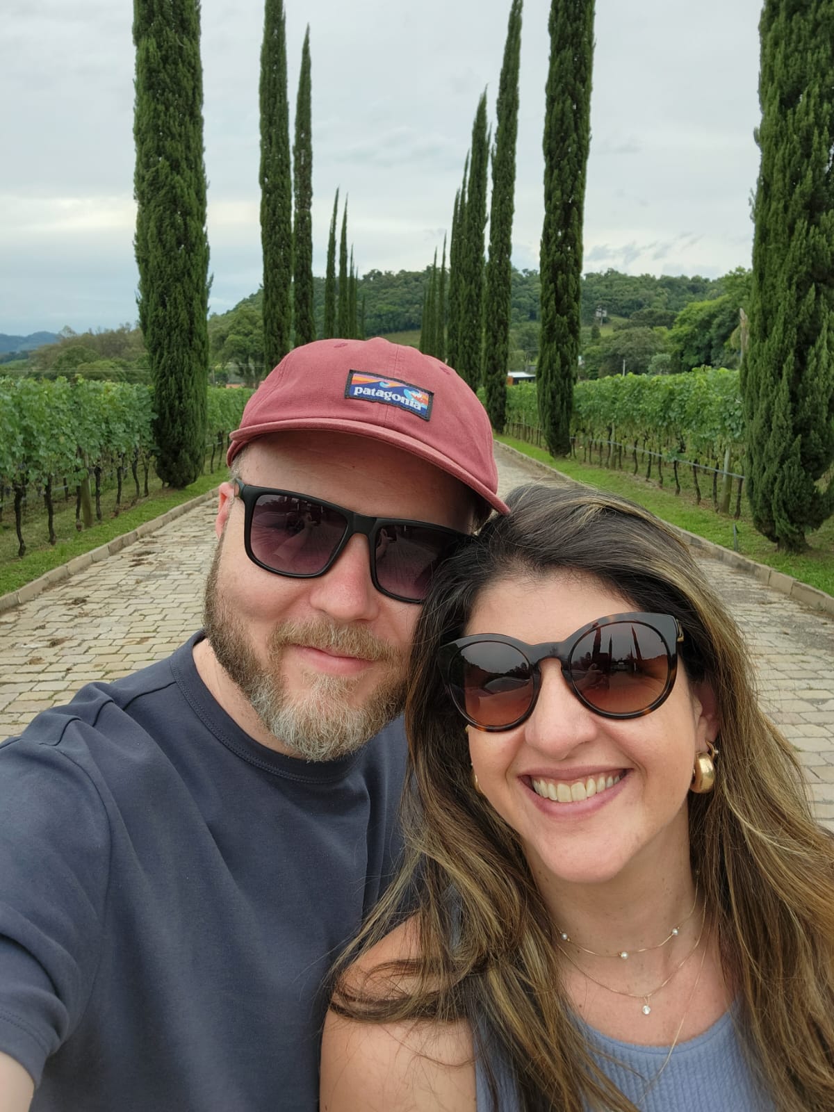 Giovanna e Carlos Augusto em um caminho entre vinhedos