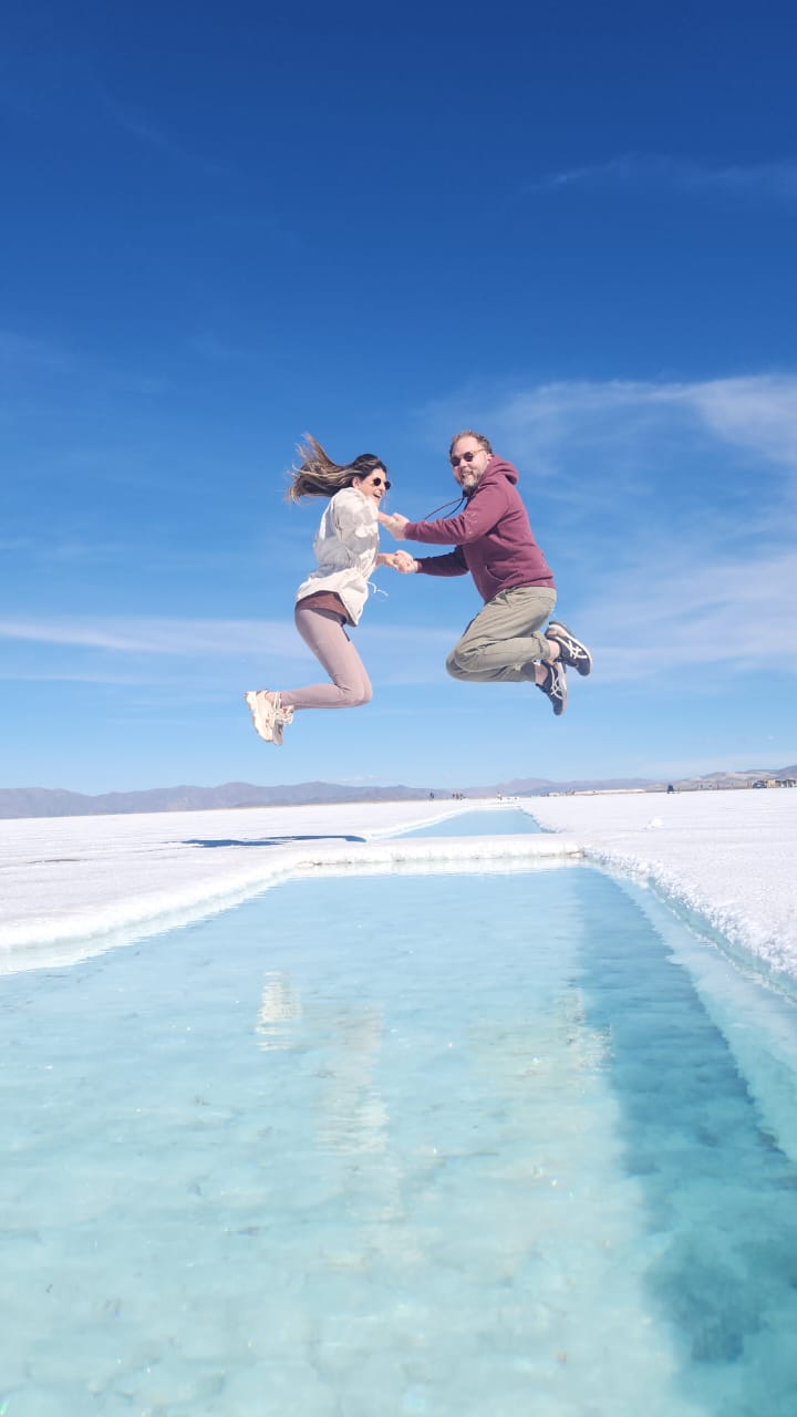 Giovanna e Carlos Augusto saltando juntos sobre o salar