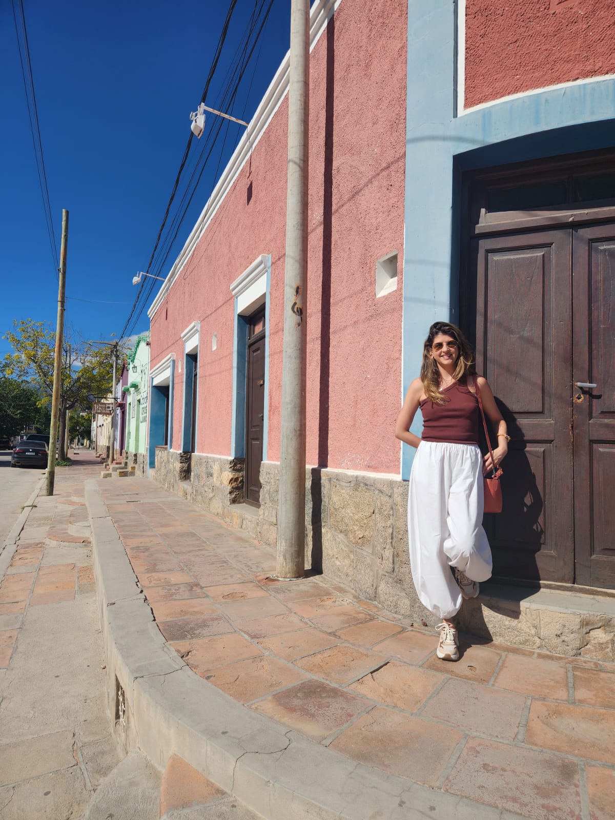 Giovanna em uma rua de fachadas coloridas